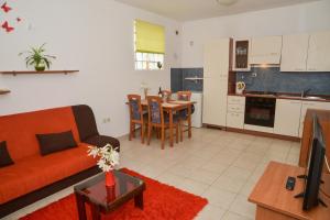 sala de estar con sofá, mesa y cocina en Latmo Apartment Zadar, en Zadar