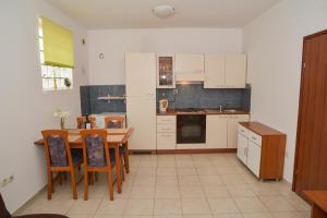 una cocina con mesa de madera y sillas. en Latmo Apartment Zadar, en Zadar