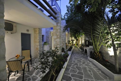 une cour avec une table et des chaises et un bâtiment dans l'établissement Alexandros Studios, à Náoussa