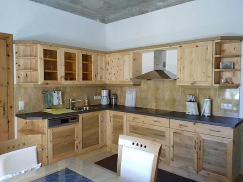 a kitchen with wooden cabinets and black counter tops at Gartler's Appartements in Kalsdorf bei Graz