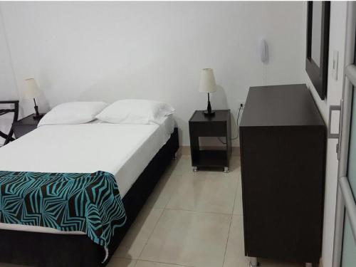 ein Schlafzimmer mit einem Bett und zwei Nachttischen und einem Bett sidx sidx sidx in der Unterkunft Hotel Septima Avenida in Neiva