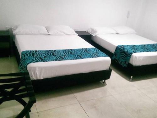 2 Betten nebeneinander in einem Zimmer in der Unterkunft Hotel Septima Avenida in Neiva