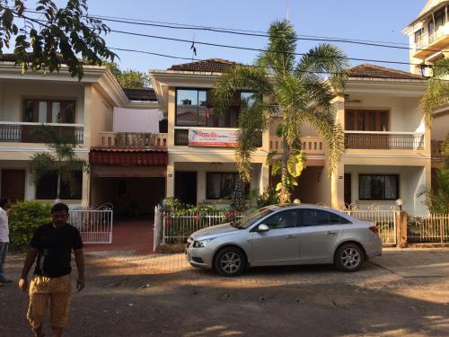 um carro prateado estacionado em frente a uma casa em Rosvilla Guest House em Benaulim