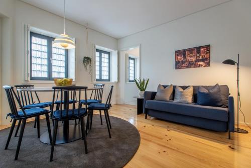 uma sala de estar com uma mesa e cadeiras e um sofá em Oporto Serviced Apartments - Alvares Cabral no Porto