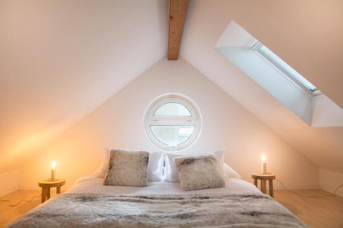 an attic bedroom with a large bed with a window at Airhome Zug Neugasse Stadtzentrum in Zug