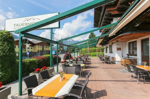 een patio met tafels en stoelen in een gebouw bij Alpenhotel Tauernstüberl in Zell am See