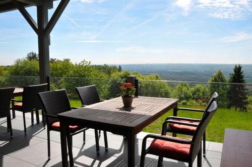 un tavolo in legno e sedie su un patio con vista di Zum Rebhang Bed & Breakfast a Oestrich-Winkel