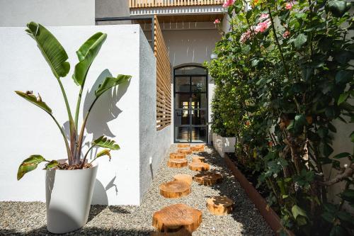 a courtyard with a plant and wooden stools at Sodium Boutique Hotel in Ciutadella