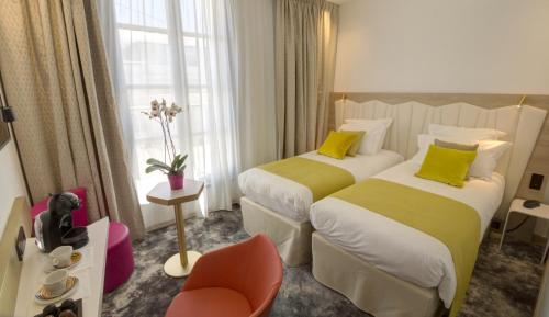 A bed or beds in a room at Best Western Plus Comedie Saint Roch