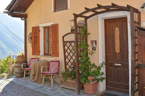 una casa con una mesa, sillas y una puerta en B&B Il Torchio, en Saint Vincent