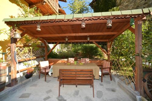 pérgola de madera con mesa y sillas en B&B Il Torchio, en Saint Vincent