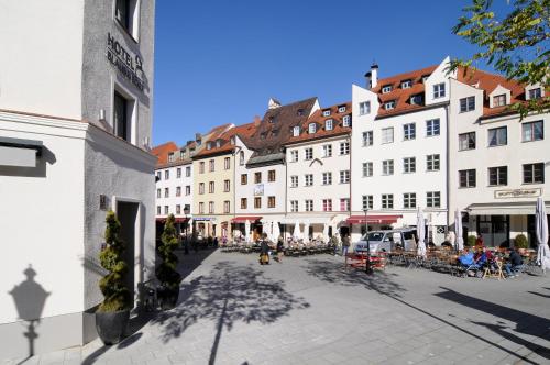 ulica miejska z budynkami i ludźmi siedzącymi na krzesłach w obiekcie Hotel Blauer Bock w Monachium