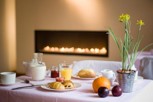 une table recouverte de assiettes de nourriture et de jus d'orange dans l'établissement Hotel Le Clos des Récollets, à Durbuy