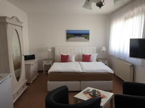 um quarto com uma cama grande e uma sala de estar em Pension Marion em Binz