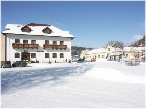 a large white building with snow on the ground at Hotel Stara Skola in Sloup