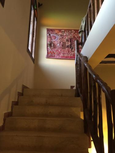 un escalier dans une maison ornée d'une peinture murale dans l'établissement Marula Park, à Diani Beach