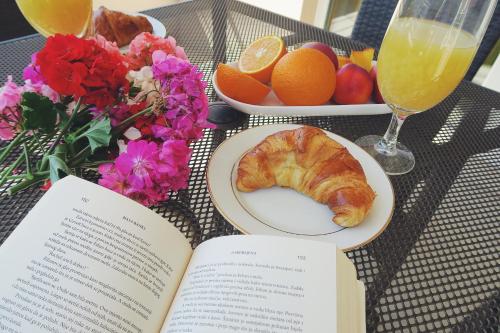 une table avec un livre et une assiette de pâtisseries et de fruits dans l'établissement Sweet Dream 2, à Dubrovnik