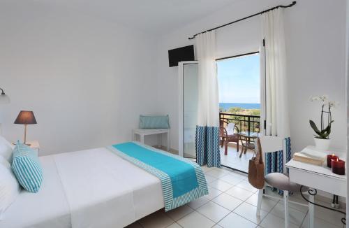 - une chambre avec un lit et une vue sur l'océan dans l'établissement Iris Beach Hotel, à Monemvasia