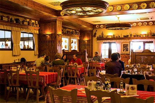 een groep mensen die aan tafel zitten in een restaurant bij Paprika Panzió in Hegyeshalom