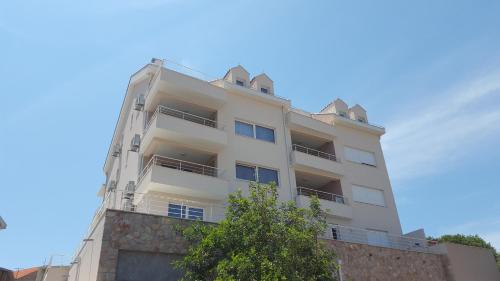 un grand bâtiment blanc avec un arbre devant lui dans l'établissement Sweet Dream 2, à Dubrovnik