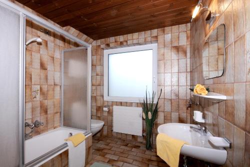 a bathroom with a sink and a tub and a toilet at Ferienwohnungen Rahm in Mayrhofen