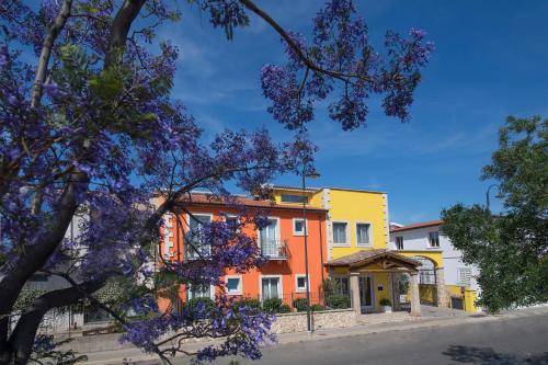 a building with a flowering tree in front of it at Marin Hotel in Pula