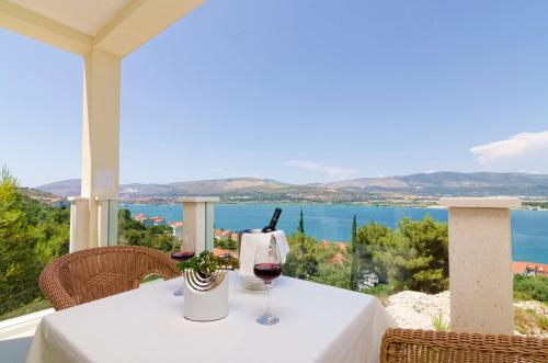 トロギールにあるLuxury Villa Star Lights Trogir - heated pool, hot tub, gym, billiardの海の景色を望むテーブル(グラスワイン付)