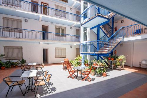 Cet appartement dispose d'une terrasse avec des tables, des chaises et des escaliers. dans l'établissement Hotel Blason Junior, à Peñíscola