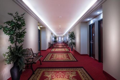 un pasillo con alfombras rojas y una fila de mesas y sillas en Skyline Hotel and Casino, en Las Vegas