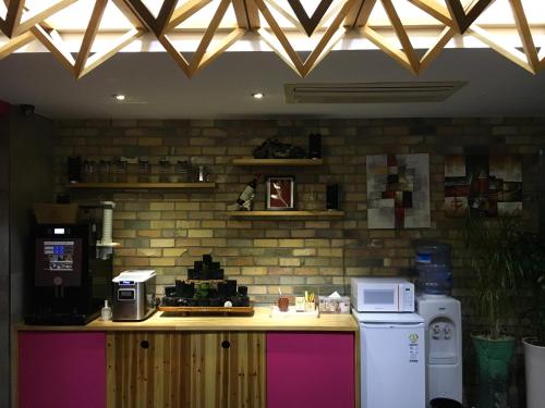 a kitchen with a counter with a microwave and a refrigerator at OHHO Hotel in Gimhae