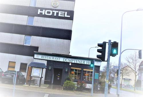 un hotel all'angolo di una strada con un semaforo di Hotel Dümptener Hof a Mülheim an der Ruhr