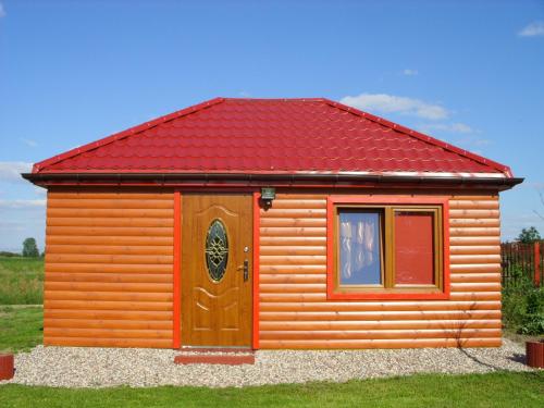 una piccola casa con tetto rosso e porta di Agroturystyka nad Biebrza Sośniaki a Goniadz