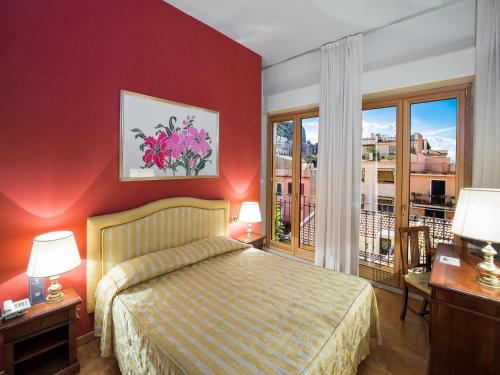 ein Hotelzimmer mit einem Bett und einem Balkon in der Unterkunft Hotel Isabella in Taormina