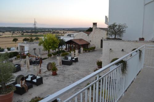 a balcony of a building with couches and tables at Masseria Torricella in Alberobello