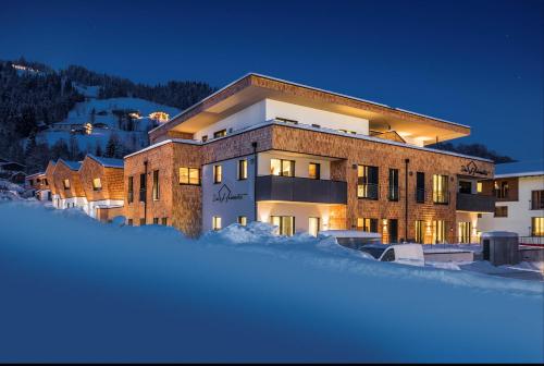 un grande edificio nella neve di notte di Das Heimsitz a Brixen im Thale