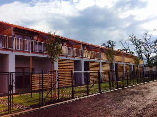 un bâtiment avec une clôture devant lui dans l'établissement Apartmany Dolni Dunajovice, à Dolní Dunajovice