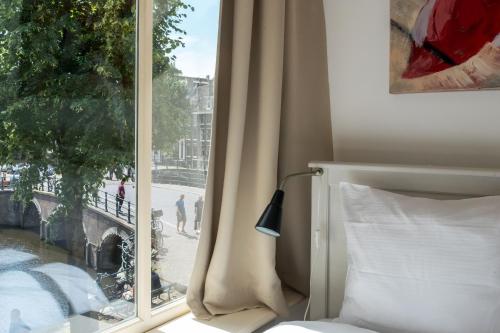 una camera da letto con finestra affacciata su una strada di The Blue Stairs ad Amsterdam