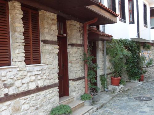 une maison en pierre avec des volets en bois dans une rue dans l'établissement Apartments Anita, à Nessebar