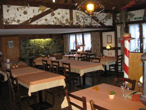 un ristorante con tavoli e sedie in una stanza di Hotel Pension Spycher a Kandersteg