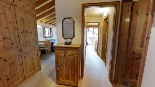 a hallway with wooden walls and a mirror on a dresser at Carla 12 in Sils Maria