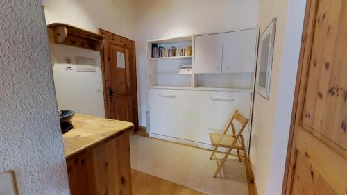 a kitchen with white cabinets and a white refrigerator at Carla 12 in Sils Maria