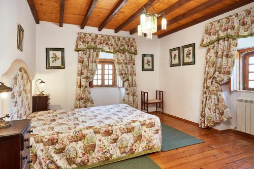 a bedroom with a bed in a room with windows at Casa D Obidos in Óbidos