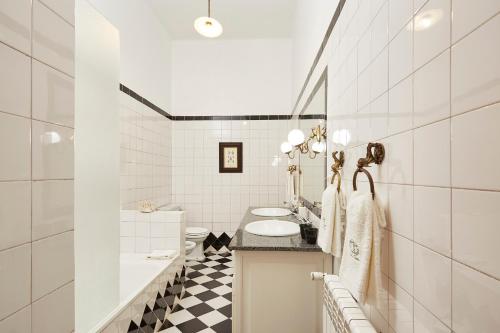 a white bathroom with a black and white checkered floor at Casa D Obidos in Óbidos