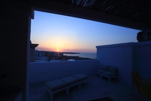 Habitación con balcón con vistas a la puesta de sol. en FONTEblu B&B, en Polignano a Mare