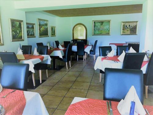 - un restaurant avec des tables et des chaises dans une salle dans l'établissement Hotel Pizzeria Selva, à Zernez