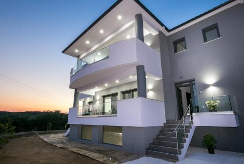 Una gran casa blanca con escaleras en la parte delantera en Il Grigio Apartments, en Limenaria