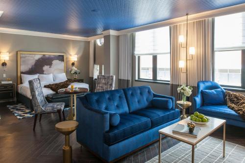 a living room with a blue couch and a bed at The Goodwin in Hartford