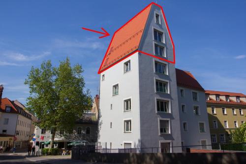 レーゲンスブルクにあるStadtturm Regensburgの赤い屋根の白い高い建物