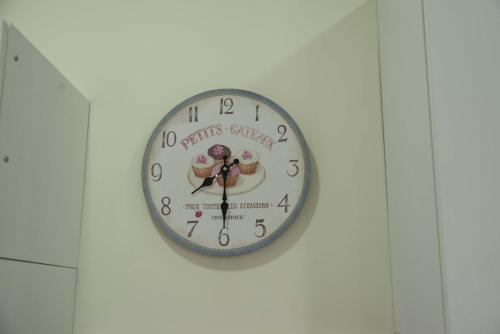 a clock on a wall with a picture of two donuts on it at La Dolce Casetta in Grottaferrata