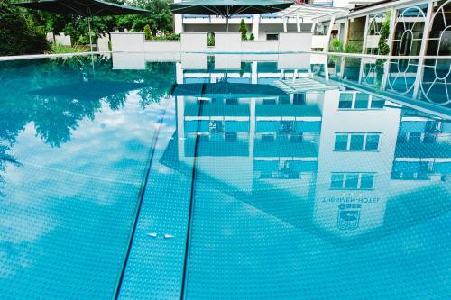 a swimming pool with blue water in front of a building at Apartmenthaus Gass in Bad Füssing